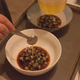 Aromatized chicken fat is added to the soy tare, with green onions at the bottom.